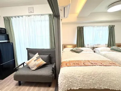 a bedroom with two beds and a tv and windows at Motosakura 401 Asakusa Ueno Akihabara Area, Bicycle Rental, 6 Minutes to Station, 2 Simmons Beds, Elevator, Direct Access to Airport in Tokyo