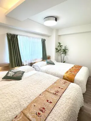 two beds sitting next to each other in a bedroom at Motosakura 401 Asakusa Ueno Akihabara Area, Bicycle Rental, 6 Minutes to Station, 2 Simmons Beds, Elevator, Direct Access to Airport in Tokyo