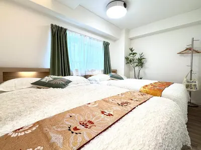two beds in a bedroom with a window at Motosakura 401 Asakusa Ueno Akihabara Area, Bicycle Rental, 6 Minutes to Station, 2 Simmons Beds, Elevator, Direct Access to Airport in Tokyo