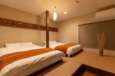 a bedroom with two beds and a large screen at \u6674\u30ec\u5c4b \u65b0\u8fb0\u7f8e\u8358 Hareya Shin-Tatsumiso in Tokyo