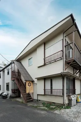 a white building with a staircase next to a parking lot at \u6674\u30ec\u5c4b \u65b0\u8fb0\u7f8e\u8358 Hareya Shin-Tatsumiso in Tokyo