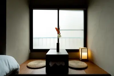 a bedroom with a vase of flowers on a table at \u6674\u30ec\u5c4b \u7b51\u6ce2\u8358 Hareya Tsukubaso in Tokyo
