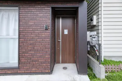 a brown door on the side of a house at \u5317\u5c0f\u5ca9\u6238\u5efa in Tokyo