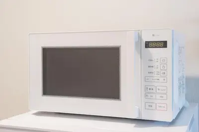 a white microwave oven sitting on top of a counter at \u5317\u5c0f\u5ca9\u6238\u5efa in Tokyo