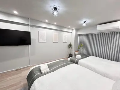 a bedroom with two beds and a flat screen tv at ying-Dōgenzaka,Shibuya city 3F-SY0065 in Tokyo
