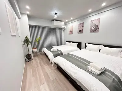 two beds in a bedroom with white walls and wood floors at ying-Dōgenzaka,Shibuya city 3F-SY0065 in Tokyo