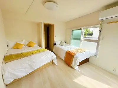 two beds in a room with a window at Ueno Sakura Inn \u4e0a\u91ce\u516c\u56ed in Tokyo