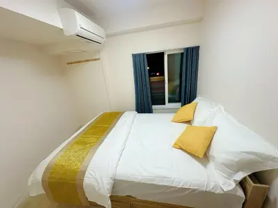 a bedroom with a bed with white sheets and yellow pillows at Ueno Sakura Inn \u4e0a\u91ce\u516c\u56ed in Tokyo