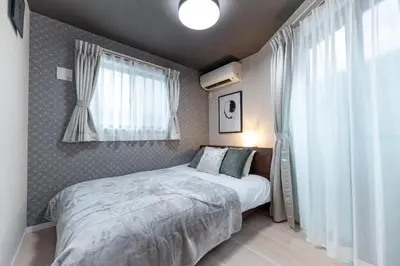 a small bedroom with a bed and a window at Hotel ITSUKI in Tokyo