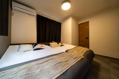 a bedroom with a large bed with white sheets at 1, Horikiri Entire house for rent, \u5800\u5207 in Tokyo
