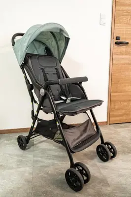 a green stroller sitting in a room at 1, Horikiri Entire house for rent, \u5800\u5207 in Tokyo