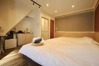 a bedroom with a large white bed and a kitchen at \u696d\u5e731\u968e \u30b9\u30ab\u30a4\u30c4\u30ea\u30fc\u30d3\u30e5\u30fc \u99c5\u8fd1 \u6700\u59273\u540d in Tokyo