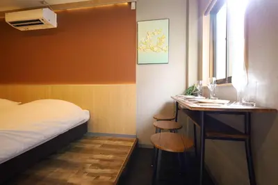 a room with a bed and a desk with two stools at \u696d\u5e731\u968e \u30b9\u30ab\u30a4\u30c4\u30ea\u30fc\u30d3\u30e5\u30fc \u99c5\u8fd1 \u6700\u59273\u540d in Tokyo
