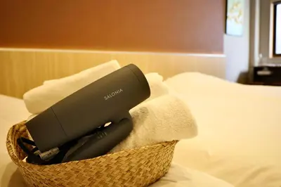 a hair dryer in a basket on a bed at \u696d\u5e731\u968e \u30b9\u30ab\u30a4\u30c4\u30ea\u30fc\u30d3\u30e5\u30fc \u99c5\u8fd1 \u6700\u59273\u540d in Tokyo