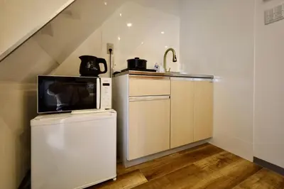 a kitchen with a microwave on top of a refrigerator at \u696d\u5e731\u968e \u30b9\u30ab\u30a4\u30c4\u30ea\u30fc\u30d3\u30e5\u30fc \u99c5\u8fd1 \u6700\u59273\u540d in Tokyo