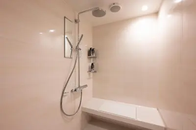 a bathroom with a shower with a shower seat at EISEI STAY Ikebukuro Nishi in Tokyo