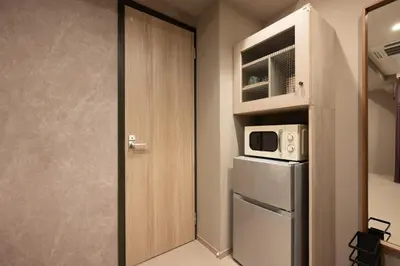 a small kitchen with a refrigerator and a microwave at EISEI STAY Ikebukuro Nishi in Tokyo