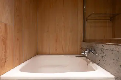 a bathroom with a white tub and a mirror at EISEI STAY Ikebukuro Nishi in Tokyo