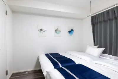 a bedroom with a bed with blue and white stripes at ef\u6c60\u888b202 in Tokyo