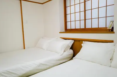 two beds sitting next to each other in a room at Akira Hiro House - Room101 in Tokyo