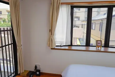 a bedroom with a bed and a large window at Akira Hiro House - Room103 in Tokyo