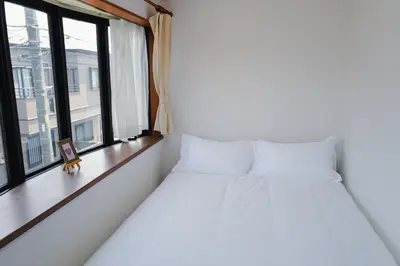 a bedroom with two beds and a window at Akira Hiro House - Room103 in Tokyo