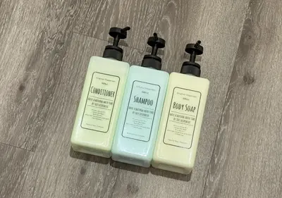 two bottles of sunscreen sitting on top of a wooden floor at ef\u6c60\u888b301 in Tokyo