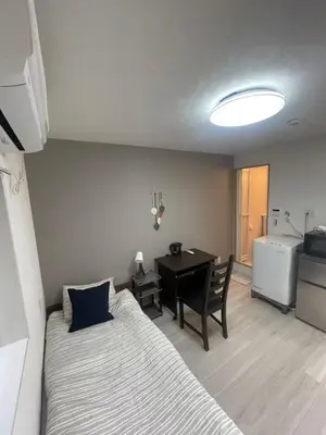 a bedroom with a bed and a desk and a table at \u6843\u6843\u5b50\u306e\u30cf\u30a6\u30b9101 in Tokyo
