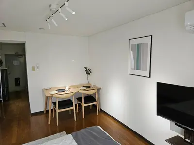 a living room with a table and chairs in a room at \u30db\u30c6\u30eb\u30ec\u30b9\u30dd\u30ef\u30fc\u30eb305 in Tokyo