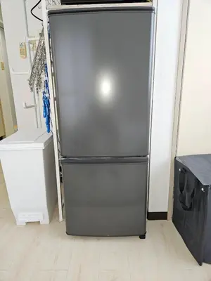 a black refrigerator sitting in a room at \u30db\u30c6\u30eb\u30ec\u30b9\u30dd\u30ef\u30fc\u30eb305 in Tokyo