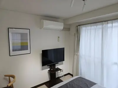a bedroom with a flat screen tv and a bed at \u30db\u30c6\u30eb\u30ec\u30b9\u30dd\u30ef\u30fc\u30eb405 in Tokyo