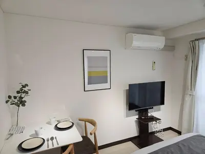 a room with a table and a tv on a wall at \u30db\u30c6\u30eb\u30ec\u30b9\u30dd\u30ef\u30fc\u30eb405 in Tokyo