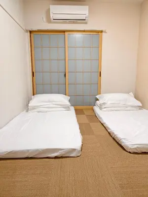 two beds in a room with white sheets at THE ONE kouennji in Tokyo
