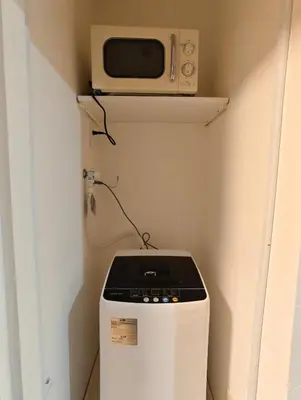 a microwave sitting on top of a refrigerator in a room at THE ONE kouennji in Tokyo