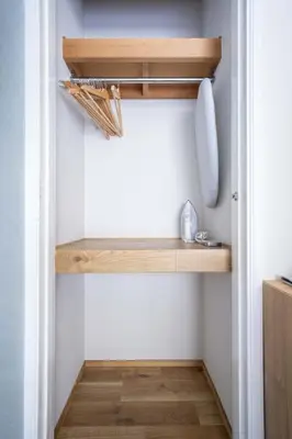 a small kitchen with wooden shelves in a closet at House Hotel Shinnakano 202 in Tokyo