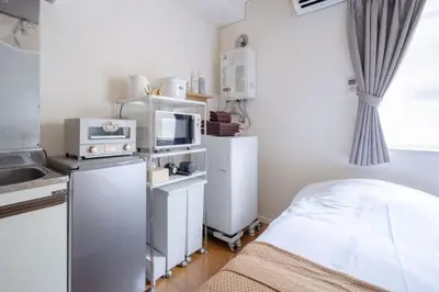 a small kitchen with a bed and a microwave at House Hotel Shinnakano 202 in Tokyo
