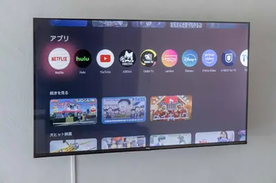 a display screen on a wall with many different logos at House Hotel Shinnakano 202 in Tokyo