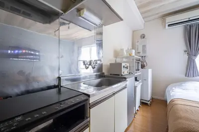 a small kitchen with a sink and a bed at House Hotel Shinnakano 202 in Tokyo