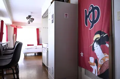 a living room with a wall with a painting on it at OMORI Red&Blue Hotel in Tokyo