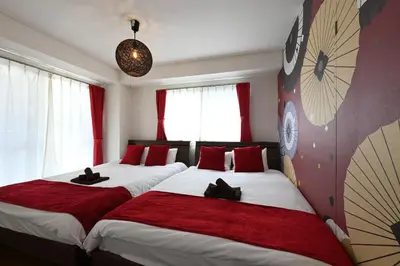 two beds in a room with red pillows at OMORI Red&Blue Hotel in Tokyo