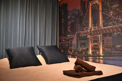 a hotel room with a bed with a towel on it at OMORI Red&Blue Hotel in Tokyo