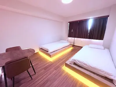 a room with two beds and a desk and a window at Spacious Family Stay Shinagawa-Kokoro House 3 in Tokyo