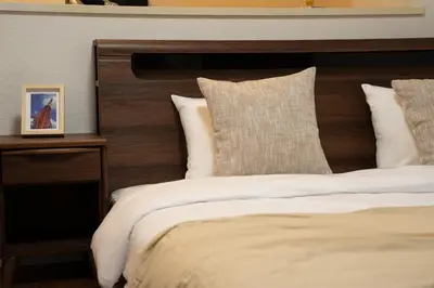 a bedroom with a large bed with a wooden headboard at Poka Premium Kuramae \u6696\u5bbf\u8535\u524d in Tokyo