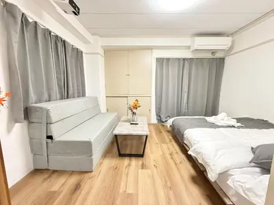 a bedroom with a bed and a couch and a table at Shinjuku Waseda D1 in Tokyo