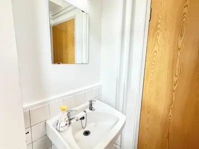 a white bathroom with a sink and a mirror at Shinjuku Waseda D1 in Tokyo
