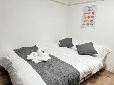 a white bed with two white towels on it at Shinjuku Waseda D1 in Tokyo
