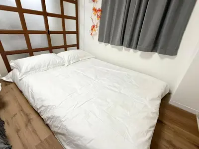 a white bed in a room with a window at Shinjuku Waseda D1 in Tokyo