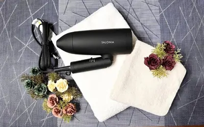 a black hair dryer sitting on a table with flowers at Amazing location Harajuku House Shibuya 8pepl 2BR in Tokyo