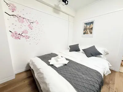 a bedroom with a bed with flowers on the wall at Shinjuku Waseda D2 in Tokyo