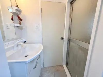 a white bathroom with a sink and a shower at Shinjuku Waseda D2 in Tokyo
